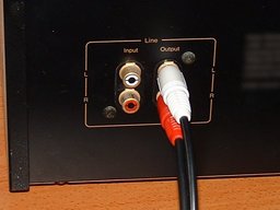 RCA cable plugged into the back of a cassette tape player.